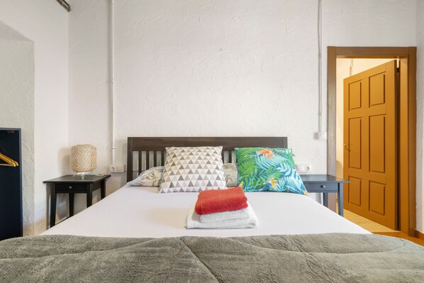 A neatly made bed with a red towel, a wooden headboard, and patterned pillows. - Adapted Room with Mountain Views, Shared Terrace and WiFi (Moraime)