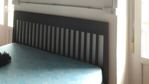 A room with a bed, a radiator, a framed picture, and a door. - Room 'Habitación Emma' with Mountain View, Shared Terrace and Wi-Fi (Moraime)