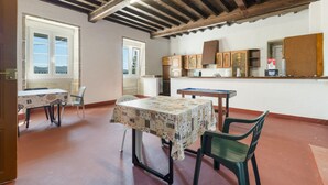 Un comedor con mesa y sillas, una cocina con armarios, y vista a través de una ventana.
