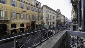 A street view with buildings, a green truck, and a metal railing. - Italianway Easy - Venezia 33 - A (Milan)