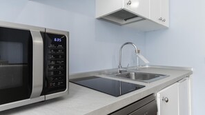 A modern kitchen with a built-in microwave, a stainless steel sink, and a dishwasher. - Italianway Easy - Venezia 33 - A (Milan)