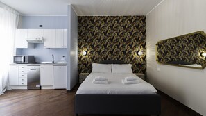 A modern hotel room with a bed, a small kitchenette, and a bathroom. - Italianway Easy - Venezia 33 - A (Milan)