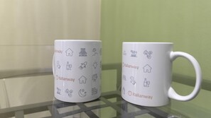 Two white mugs with Italianway branding and various icons on a glass surface. - Italianway Easy - Venezia 33 - B (Milan)