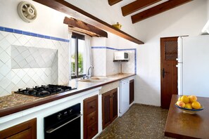 A kitchen with a gas stove, a microwave, and a sink. - Hillside Villa with Pool for 5 (Pollensa / Pollença)