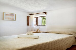 A bedroom with a bed, a window, a bedside table, and a picture on the wall. - Hillside Villa with Pool for 5 (Pollensa / Pollença)