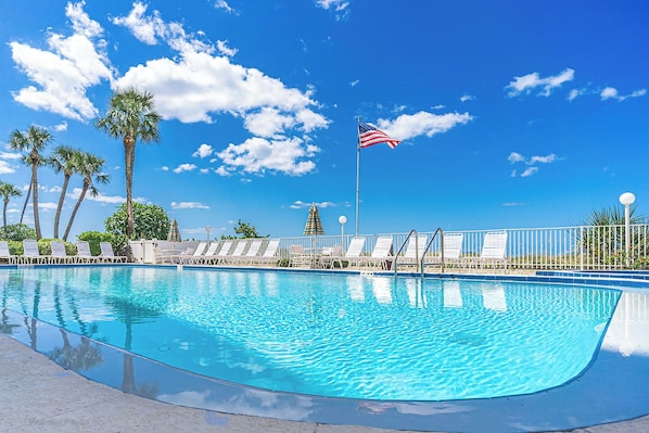 Ein Schwimmbecken mit Liegestühlen und einer US-amerikanischen Flagge.