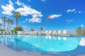 Una piscina con sillas de descanso y una bandera estadounidense.