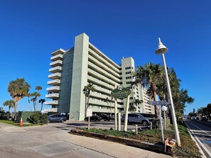 Un edificio de gran altura con varios balcones, una farola y un cartel que indica Sand Castle Condominiums.
