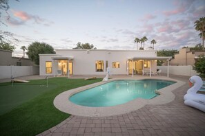 A modern house with a swimming pool, a tennis court, and a patio area. - Desert Bliss Villa - 3 bedroom Heated Pool, Putting Green, Pool Table & Games (Phoenix)