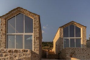 A stone building with large windows and a staircase leading to a higher level.