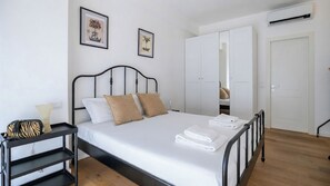 Une chambre à coucher comprenant un lit, une table de chevet, une armoire et un miroir.