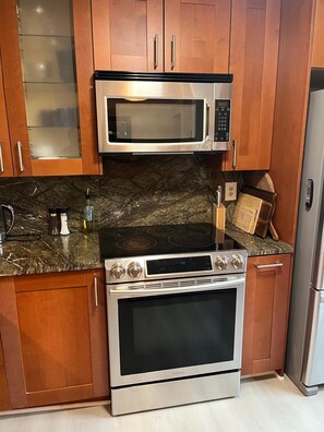 A kitchen with a stainless steel microwave, oven, and stove. - Lovely 3-bedroom townhome with AC in vibrant Arlington (Arlington)