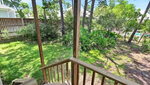A wooden deck with a railing, surrounded by a grassy yard and trees. - Ash at the Beach (Santa Rosa Beach)