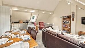 Un moderno espacio tipo loft con comedor, zona de estar acogedora y cocina.