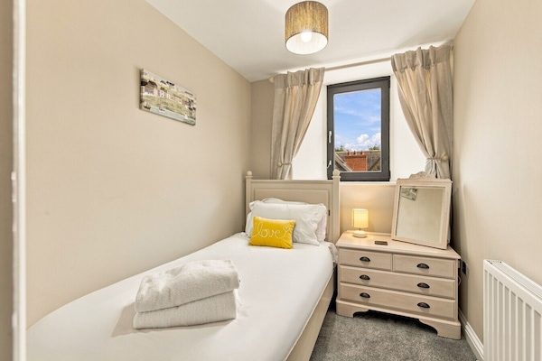 Single bedroom with chest of drawers and rooftop views.