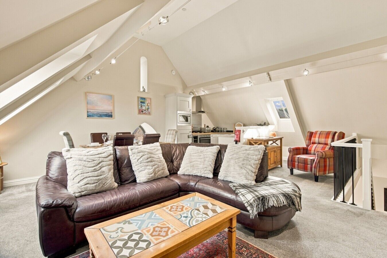 Ein gemütliches Loft mit einer braunen Ledersofa, einem Holztisch und einer Küche im Hintergrund.