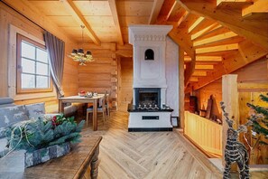 A cozy log cabin interior with a fireplace, wooden furniture, and a herringbone floor pattern. - Holiday home in Podhale, jacuzzi, sauna (Murzasichle)