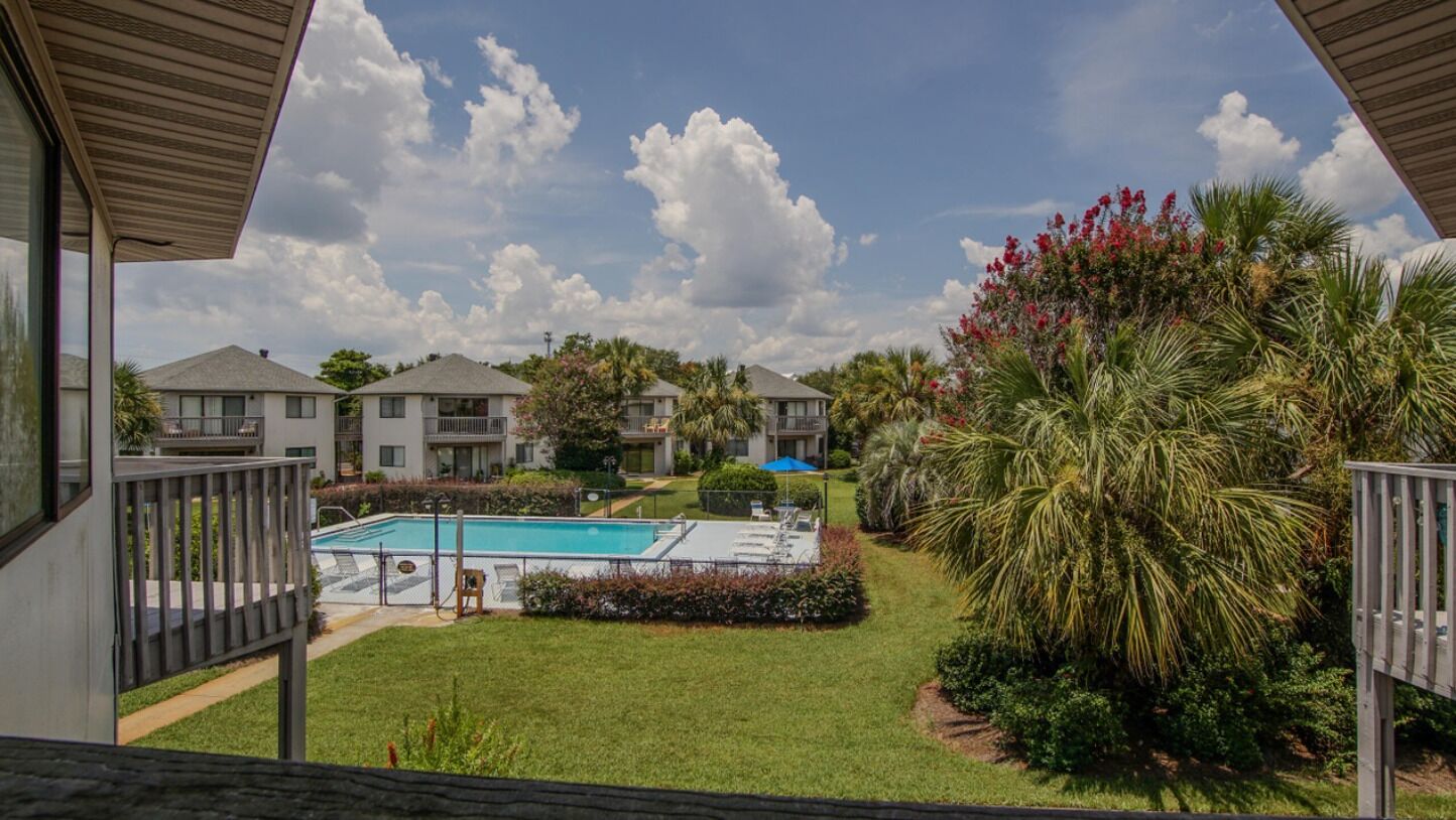 Zona residencial con piscina, varias casas y abundante vegetación.