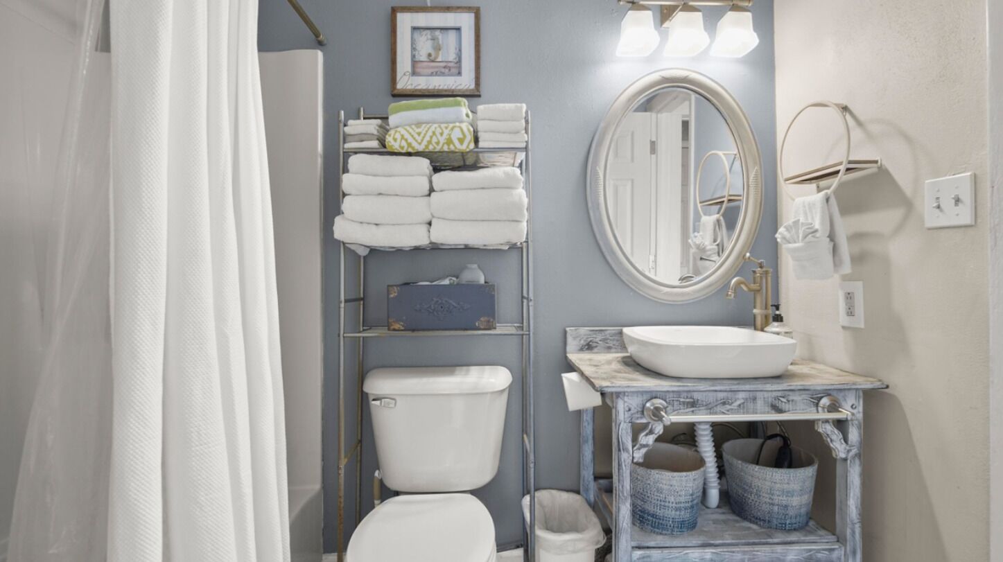 Une salle de bain équipée de toilettes, d’un lavabo et d’un porte-serviettes.