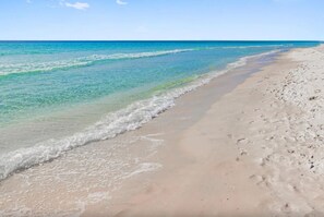 Una playa con agua cristalina y una orilla arenosa.