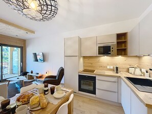 Eine moderne Küche mit eingebautem Ofen, Mikrowelle und einer Holz Arbeitsplatte.