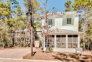 A two-story house with a covered porch, a street lamp, and a sign indicating 'Southern Tides, Clinton, Miss.' - Discover Southern Tides with Bonheur Vacations! (Watersound)
