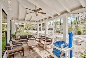 A covered outdoor seating area with wooden furniture and a ceiling fan. - Discover Southern Tides with Bonheur Vacations! (Watersound)