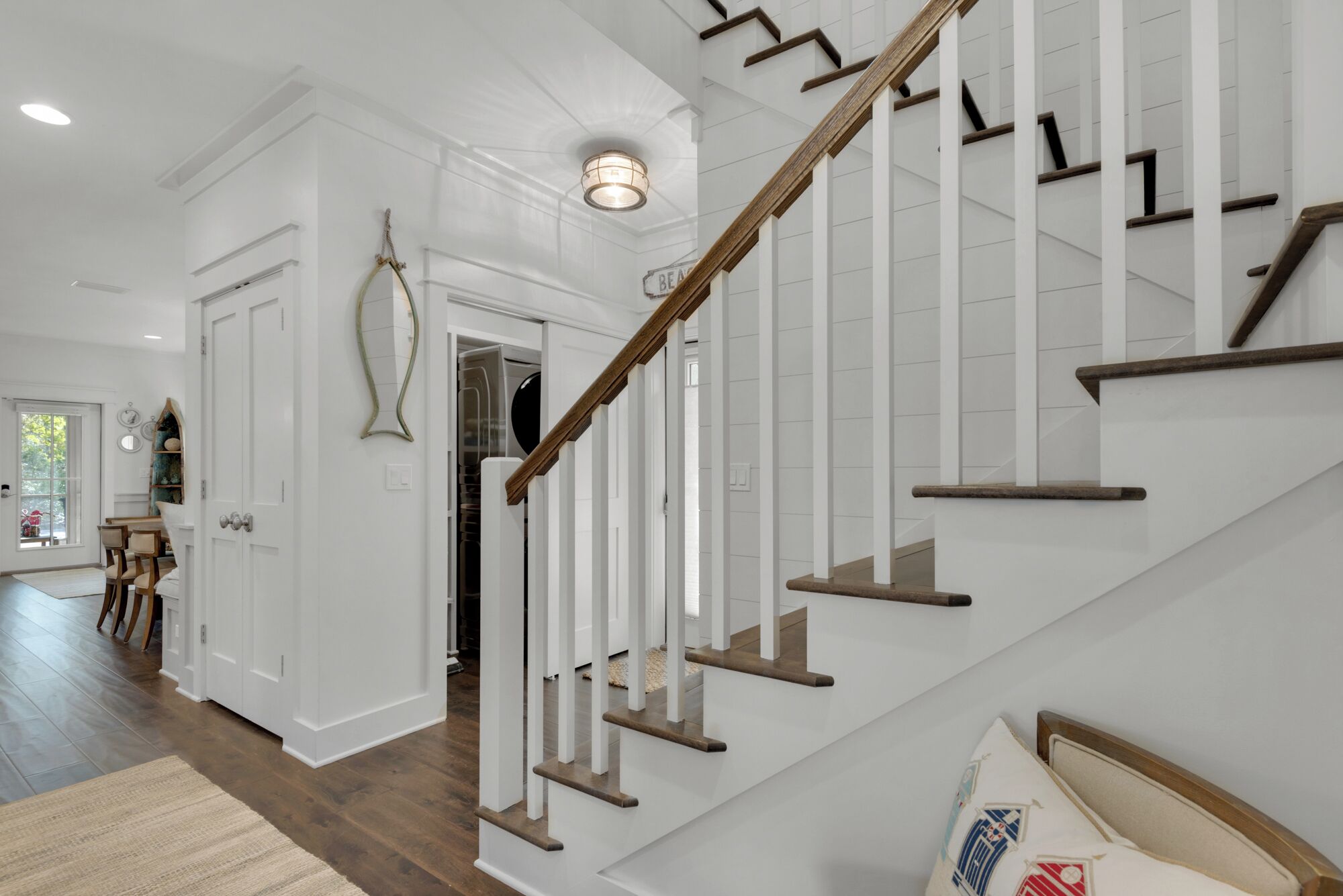 A staircase with wooden steps and white railings, leading to an upper floor.