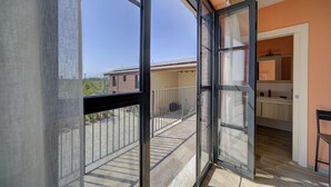 A balcony with a view of neighboring buildings and a clear sky. - Single Use   Arielle Dombasle (Roata Paoletti)