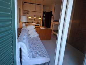 Un intérieur moderne comprenant un canapé, une table à manger en bois et un coin cuisine.
