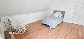 A bedroom with a bed, a chair, and a door. - Spacious home a stones throw from Newfound Lake (Bristol)