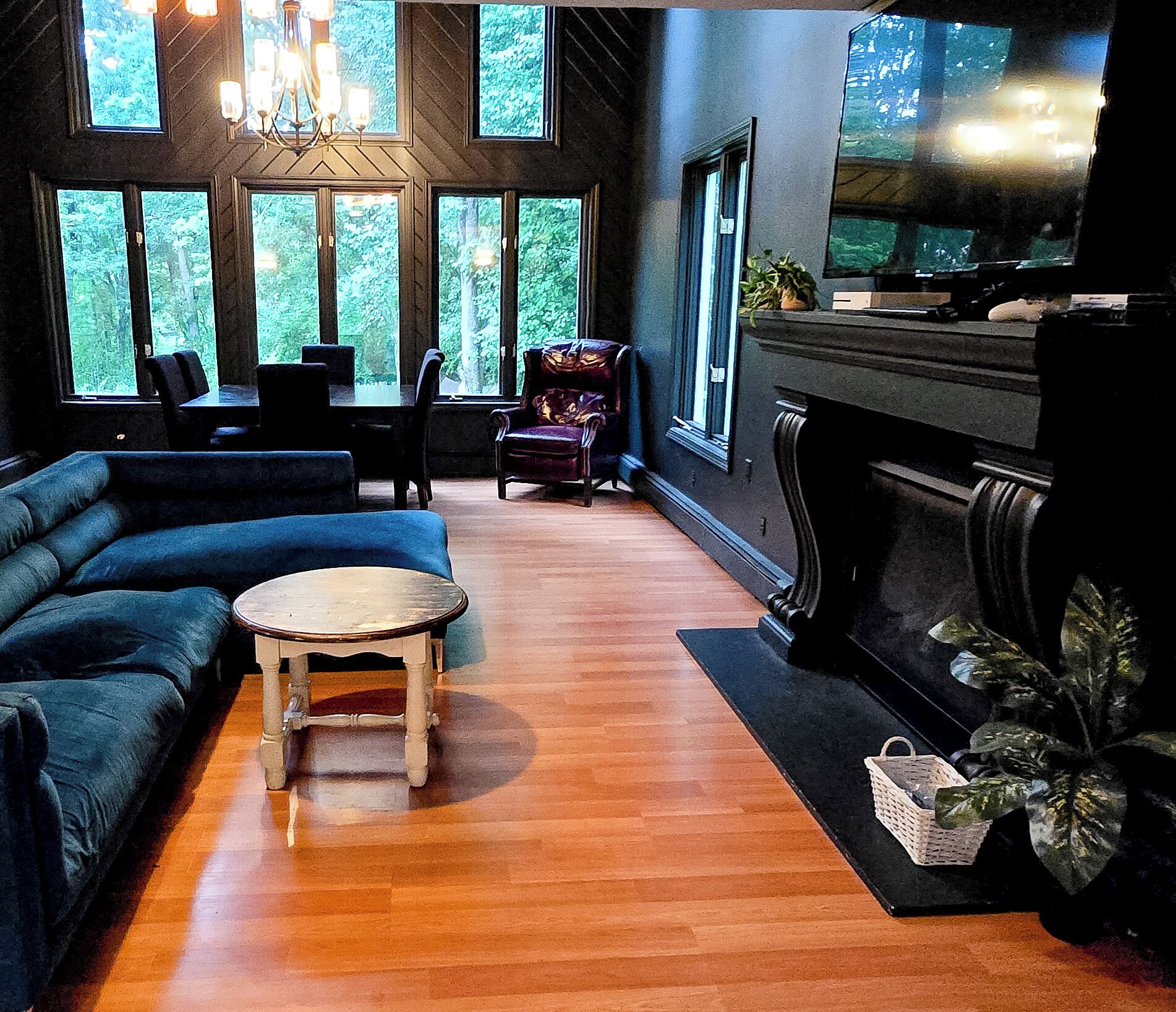 A room with a blue sofa, a small round table, and a fireplace.