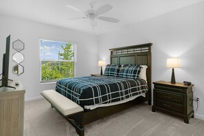 A bedroom with a bed, bedside tables, a bench, a ceiling fan, and a window with blinds. - Dog-Friendly 3BR Designer Home with Spa & 4-Seat Golf Cart (The Villages)