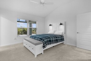 Ein Schlafzimmer mit Bett, Nachttisch, Fenster und Tür.
