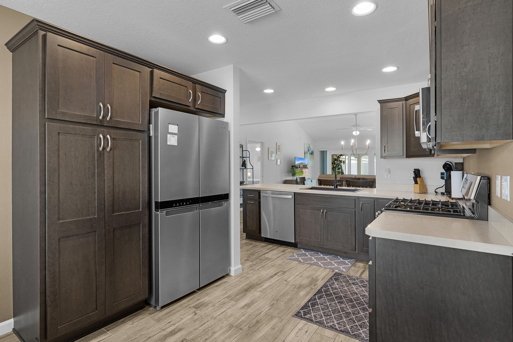 A modern kitchen with dark cabinetry, stainless steel appliances, and a central island.