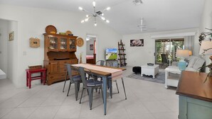 Un amplio salón con una mesa de comedor, sillas, televisor y sofá.
