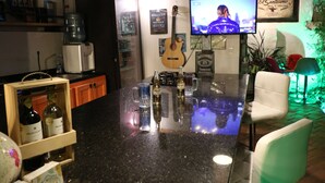 A bar area with a television, a guitar, and various bottles. - Hotel Boutique Santa Helena (Villa de Leyva)
