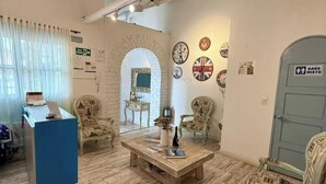 A hotel lobby with a reception desk, seating area, and decorative wall elements. - Hotel Boutique Santa Helena (Villa de Leyva)