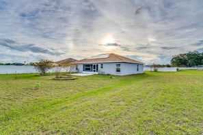 A single-story house with a sloped roof, a front porch, and a fenced yard. - Merrimack Place - Spacious Family Retreat Near Disney – Davenport, Florida (Davenport)