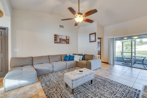 A living room with a sectional sofa, a coffee table, and a ceiling fan. - Merrimack Place - Spacious Family Retreat Near Disney – Davenport, Florida (Davenport)