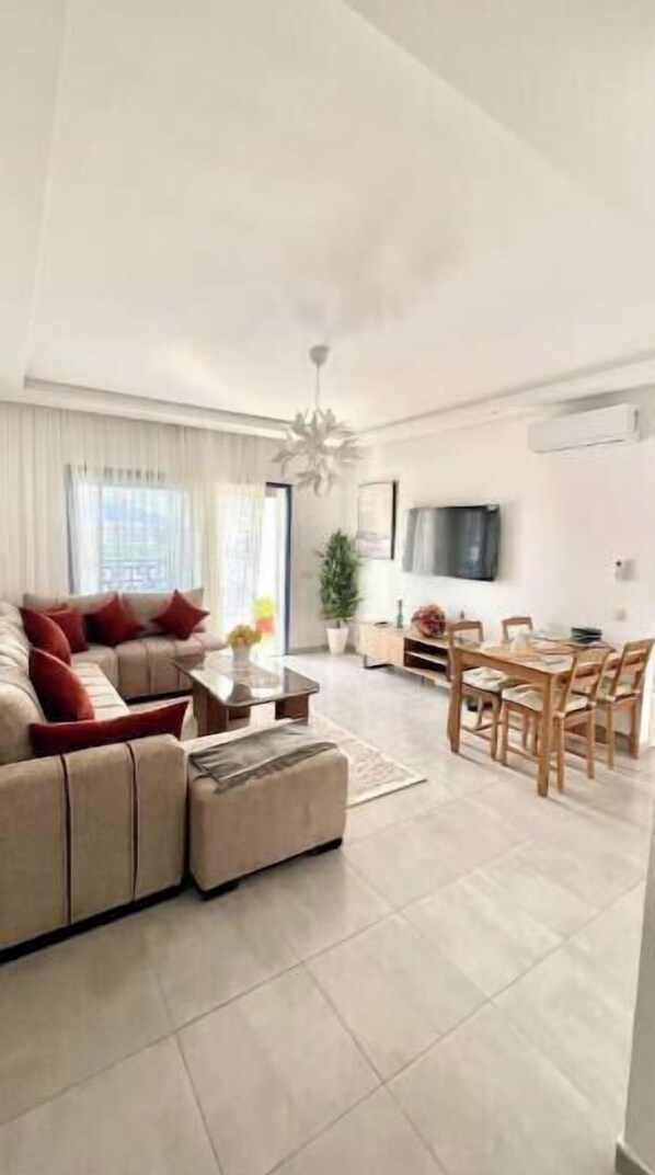 A modern living room with a sofa, coffee table, and dining area. - Ideal apartment for families (Martil)