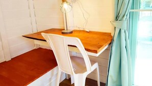 A small room with a wooden table, a white plastic chair, a desk lamp, and a window with curtains. - koh phaluai beach cottage (Chang Wat Surat Thani)