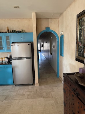 A kitchen with a stainless steel refrigerator, blue cabinets, and a wooden floor. - Condo in Time Square, Oceanfront, Puerto Penasco. Huge 3 bedrooms 3.5 bathrooms (Puerto Peñasco)