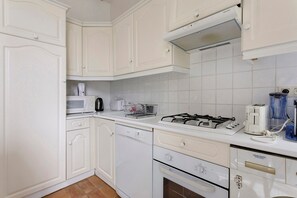 A kitchen with white cabinets, a gas stove, a dishwasher, and a microwave. - Apartment '2 Bedroom  Cannes Center' (Cannes)