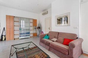 A living room with a sofa, a glass coffee table, a patterned rug, a wardrobe, and a painting on the wall. - Apartment '2 Bedroom  Cannes Center' (Cannes)