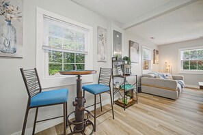 Ein modernes Wohnzimmer mit Couch, Sesseln, einem Couchtisch und Kunstwerken an den Wänden.