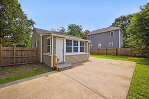 A small, single-story building with a covered porch and a concrete driveway.