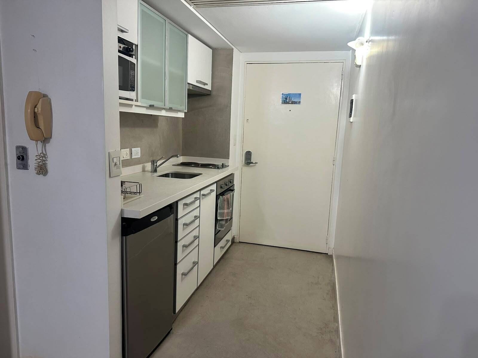 A compact kitchen with a microwave, stove, and dishwasher.