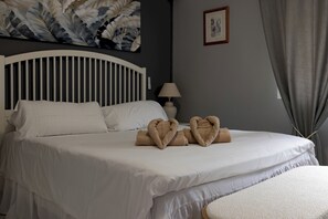 A hotel room with a bed, pillows, a bedside lamp, a picture on the wall, and a window with curtains. - La Pomonita - Two Bedroom Apartment, Sleeps 4 (Nerja)