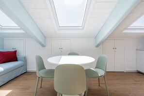 A modern interior with a skylight, a round table, and two chairs. - Casalina 2 - One Bedroom Apartment, Sleeps 4 (Napoli)